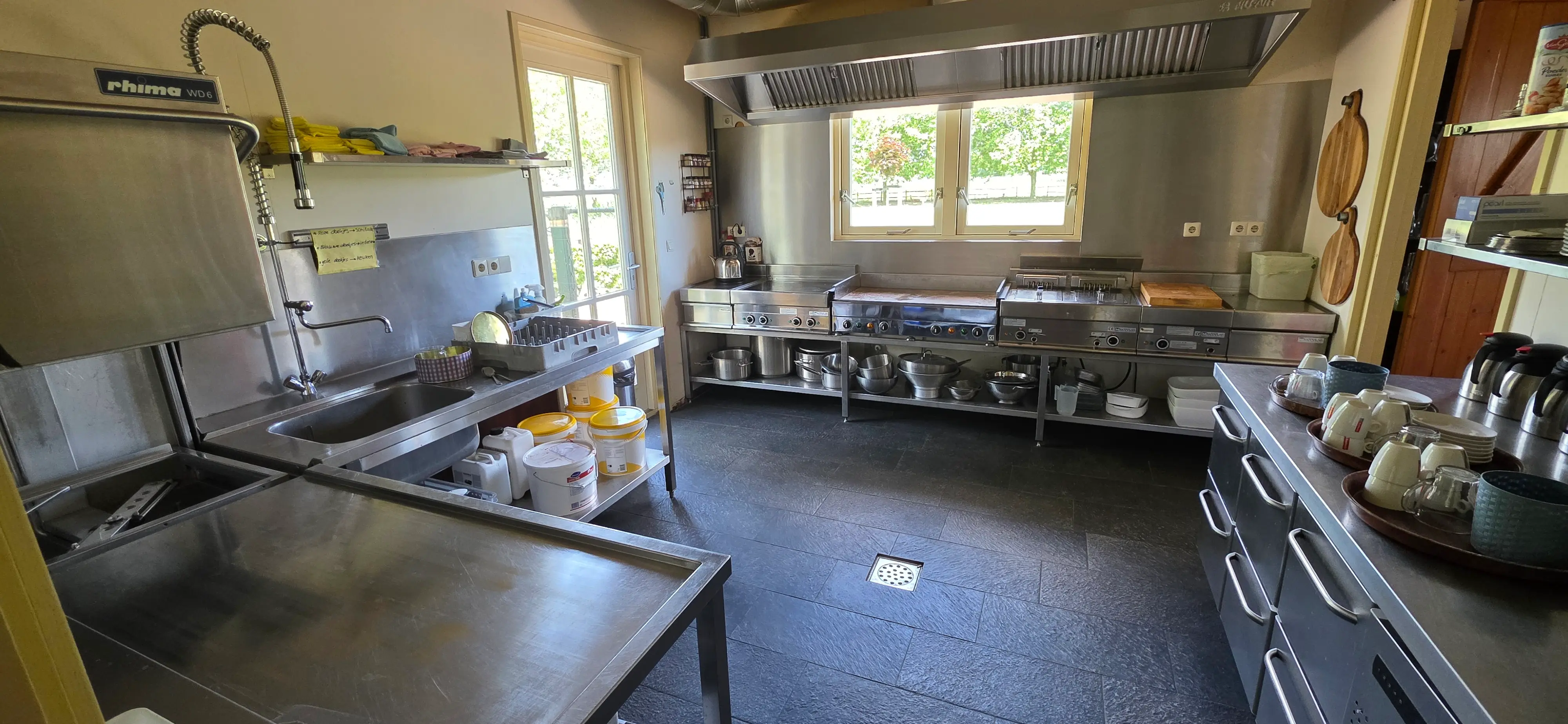 De ruime keuken van De Walkant met roestvrijstalen aanrecht en een dienblad met kopjes klaar voor de koffie.
